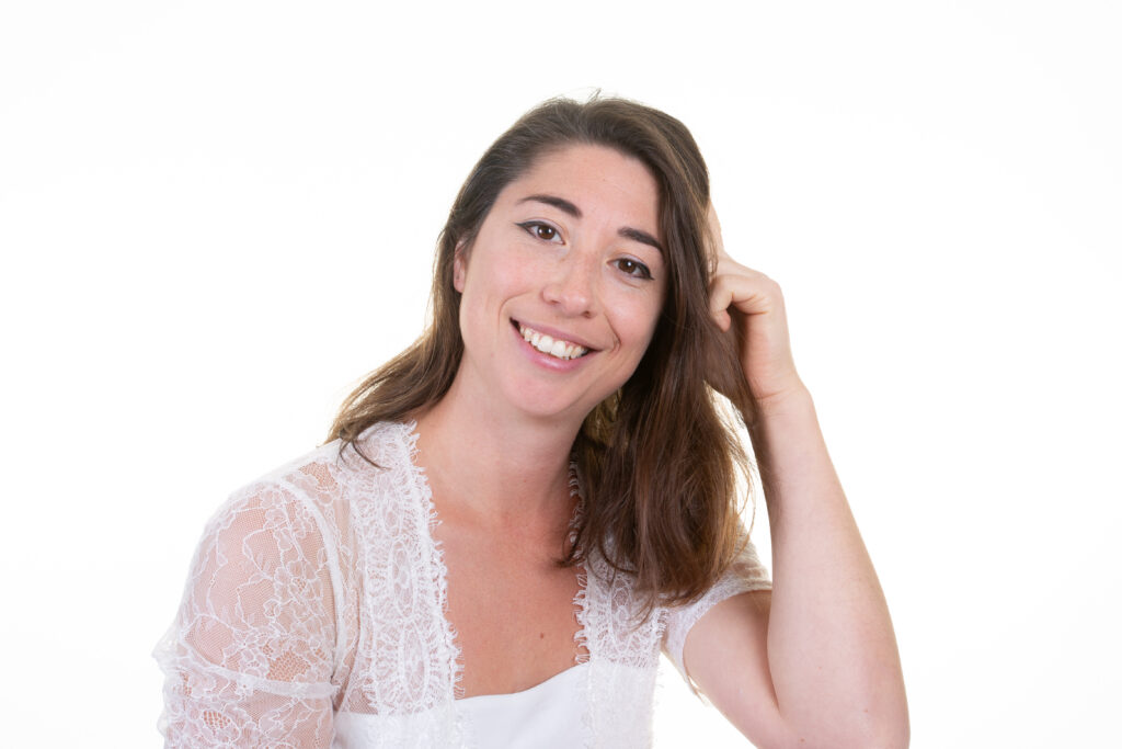 Portrait de Roxane Simeoni souriante dans un studio sur fond blanc